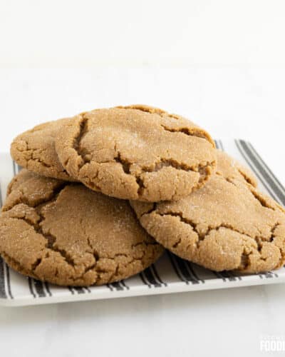 Gingersnap cookies on a black and white striped plate.