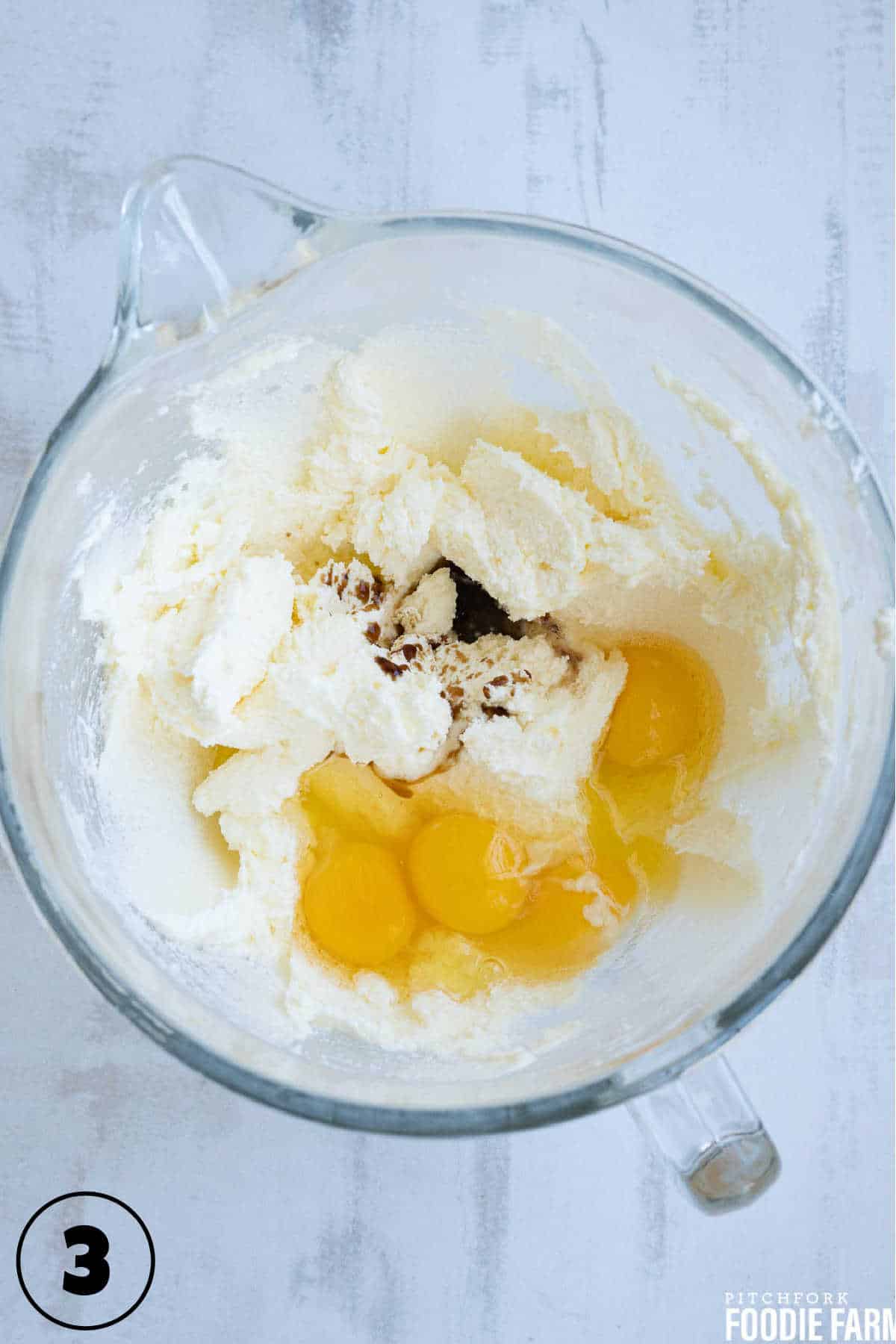 Creamed butter and sugar with eggs and vanilla extract in a mixing bowl.