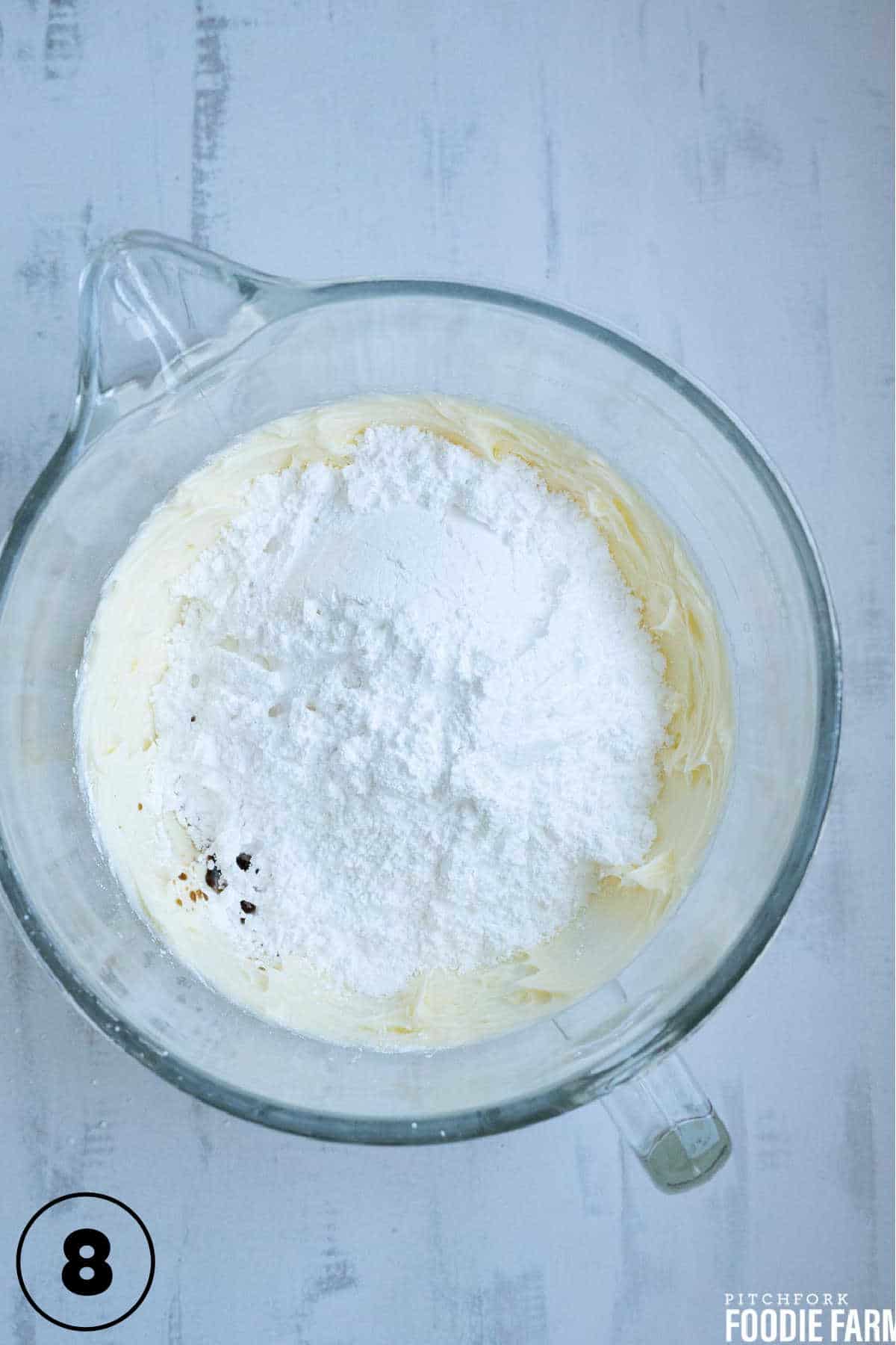 Beaten butter with powdered sugar and vanilla in a mixing bowl to make butter cream frosting.