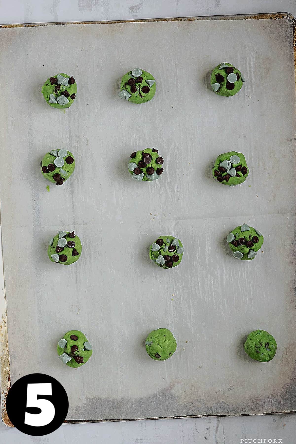 Mint cookie dough balls on cookie sheet.