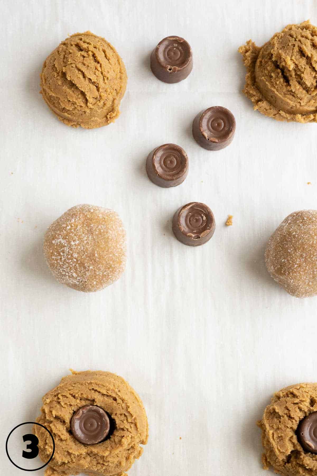 A baking sheet with rolled cookies and chocolate candies.