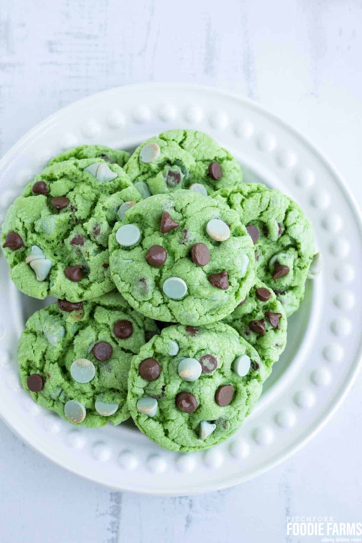 Mint cookies with chocolate chips on a white plate.