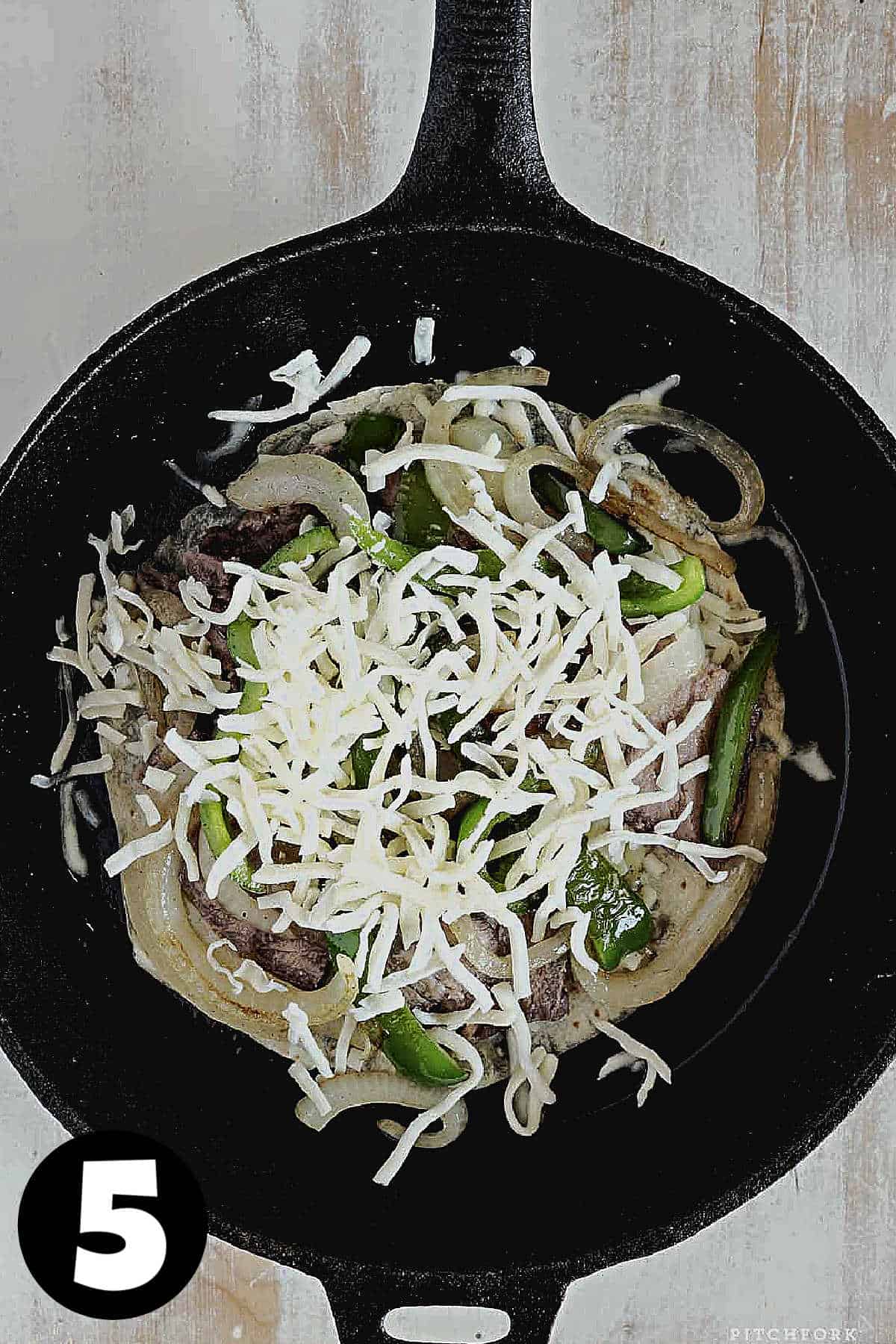 A quesadilla with steak and cheese in a cast iron skillet.