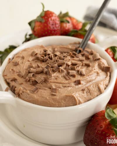 Chocolate dip with chocolate curls on top surrounded by fresh fruit.