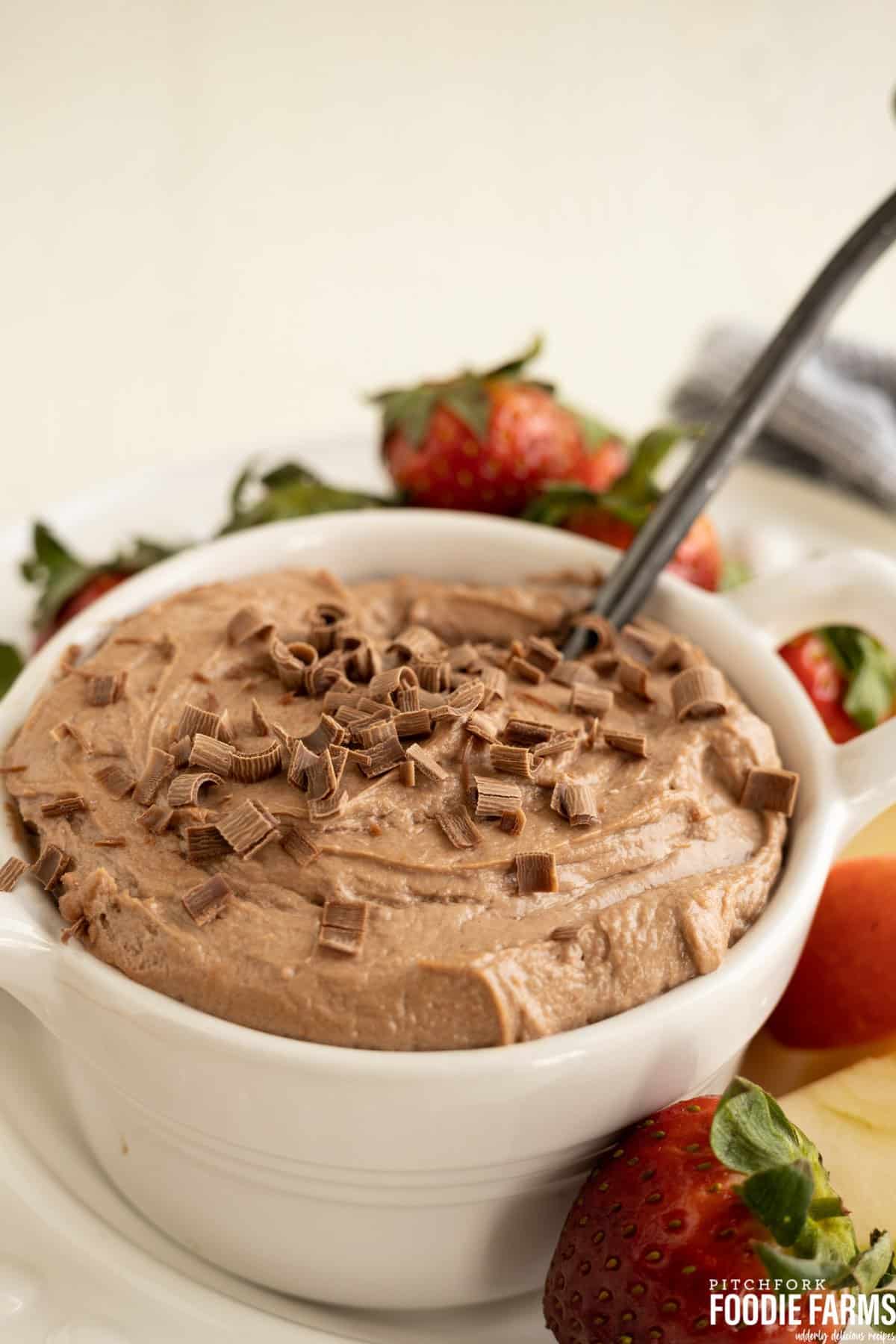 A bowl of fluffy chocolate dip with strawberries and fresh fruit.