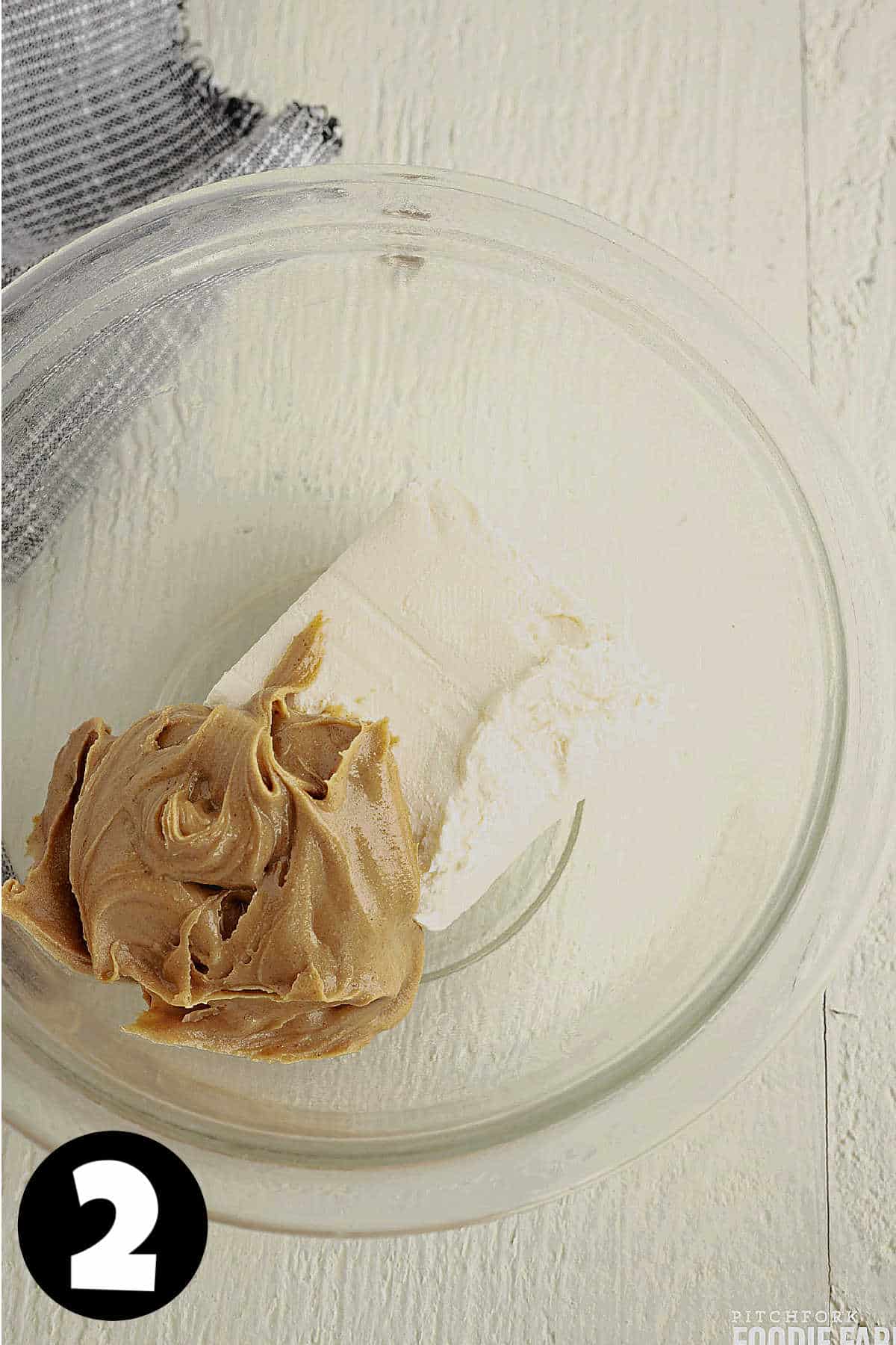 A bowl with peanut butter and cream cheese.