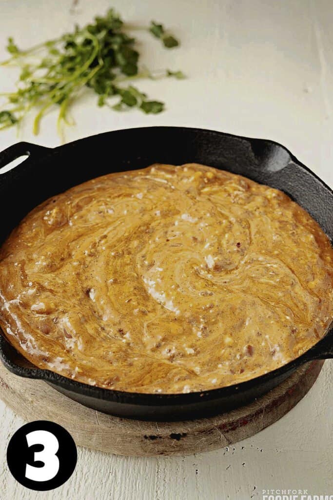 Chili cheese dip in a cast iron skillet.