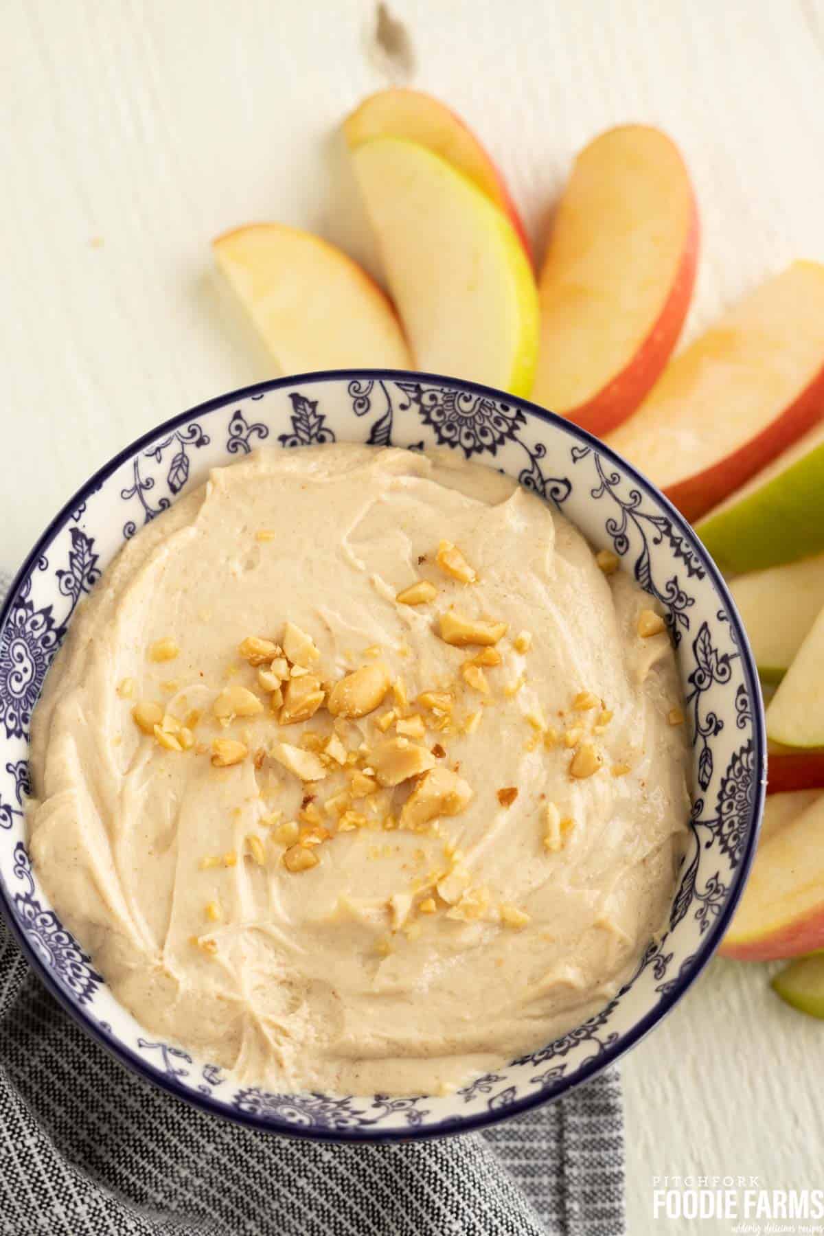 Peanut butter fruit dip in a bowl with sliced fresh apples.