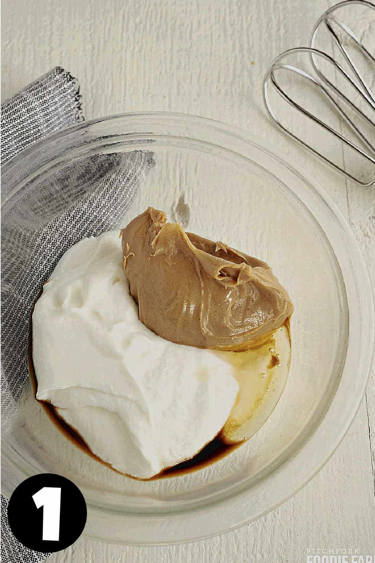 Peanut butter, Greek yogurt, vanilla, and honey in a glass mixing bowl.
