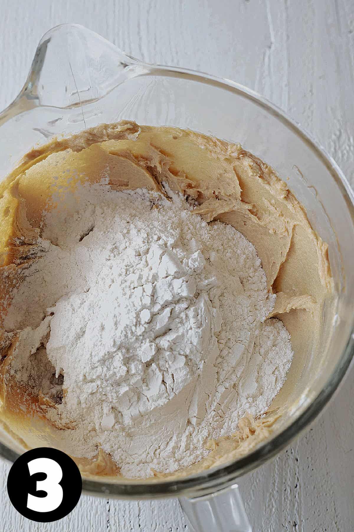 Flour being added to peanut butter cookie dough.