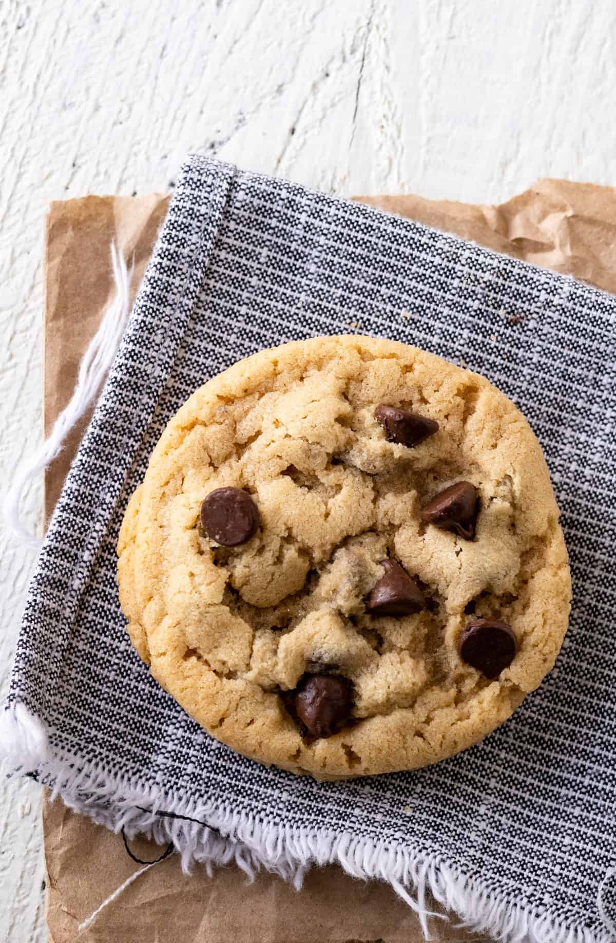 Chocolate chip peanut butter cookie on a blue napkin.