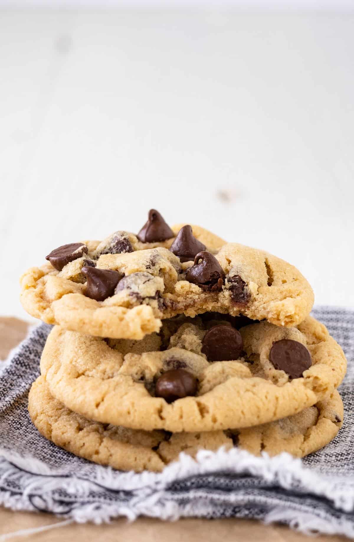 A stack of chocolate chip cookies with a bite taken from one.