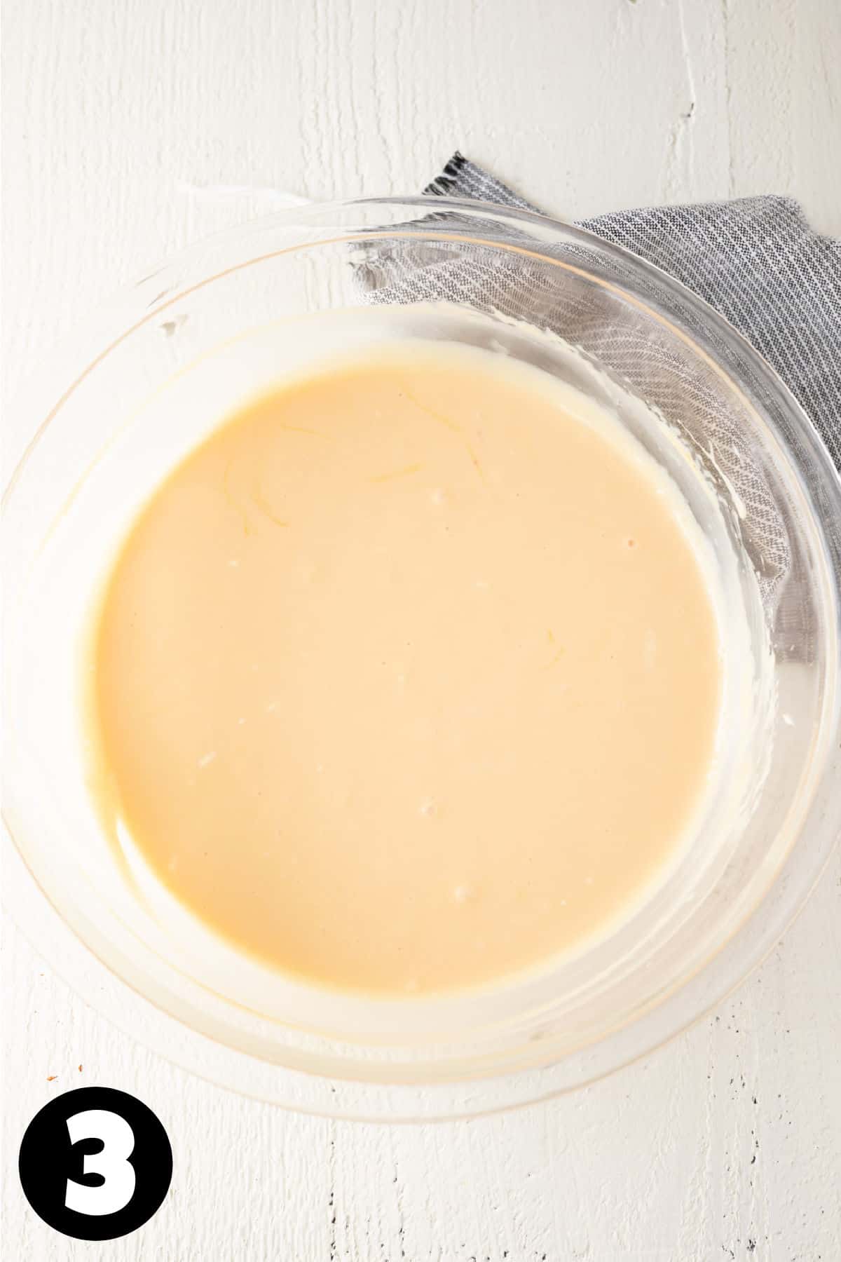 Orange cheesecake filling in a mixing bowl.