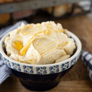 A bowl with honey butter drizzled with honey.