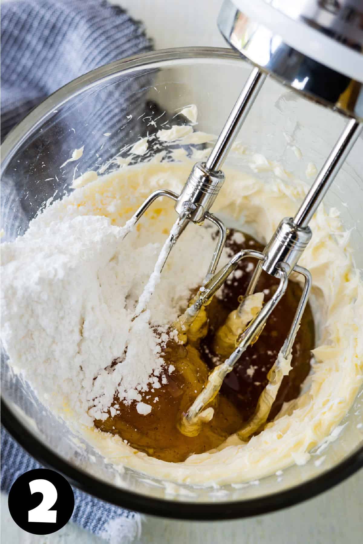 A mixing bowl with fluffy butter, honey, and powdered sugar.