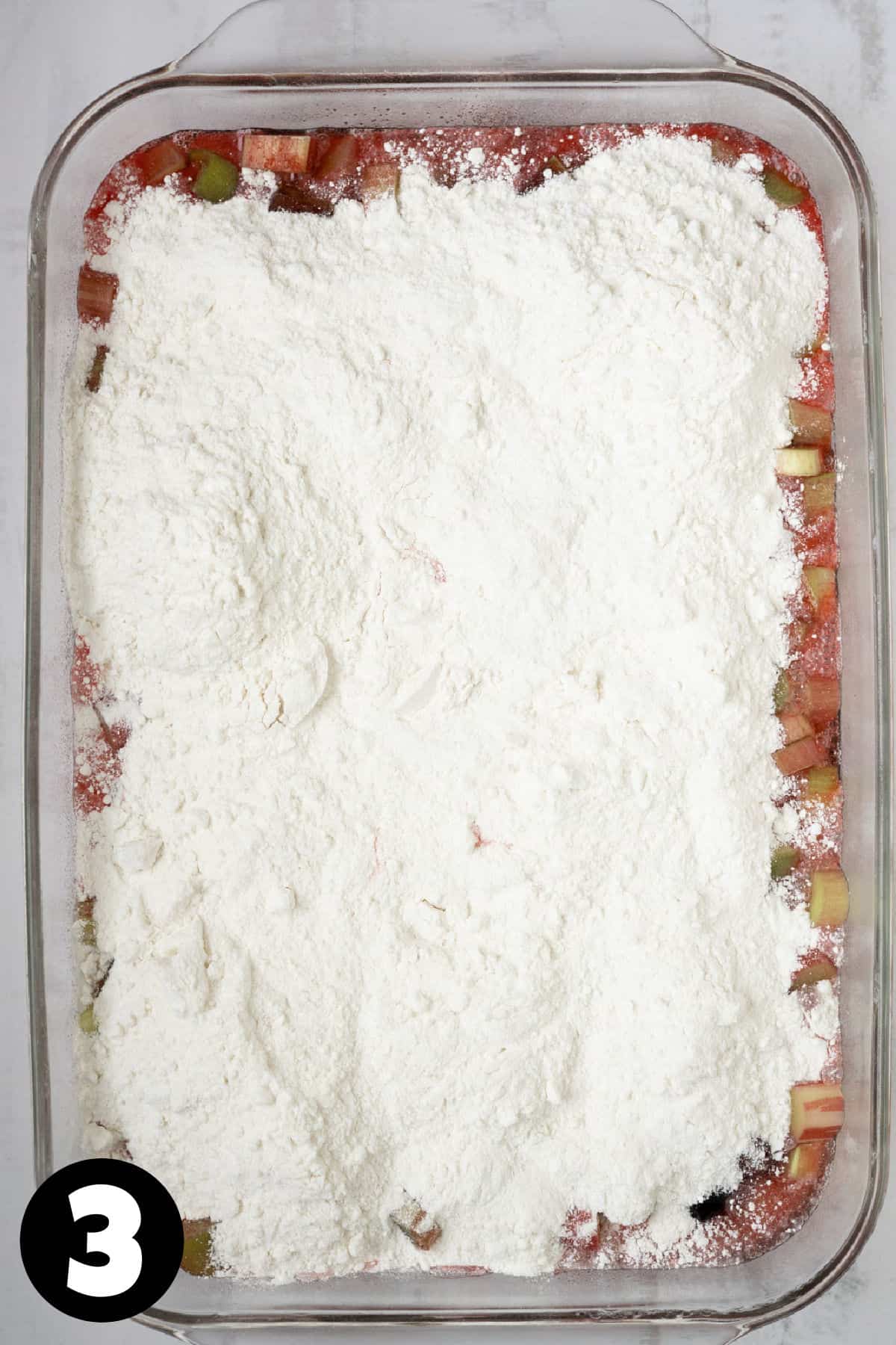 Unbaked fruit dump cake with dry boxed cake mix sprinkled over the top.