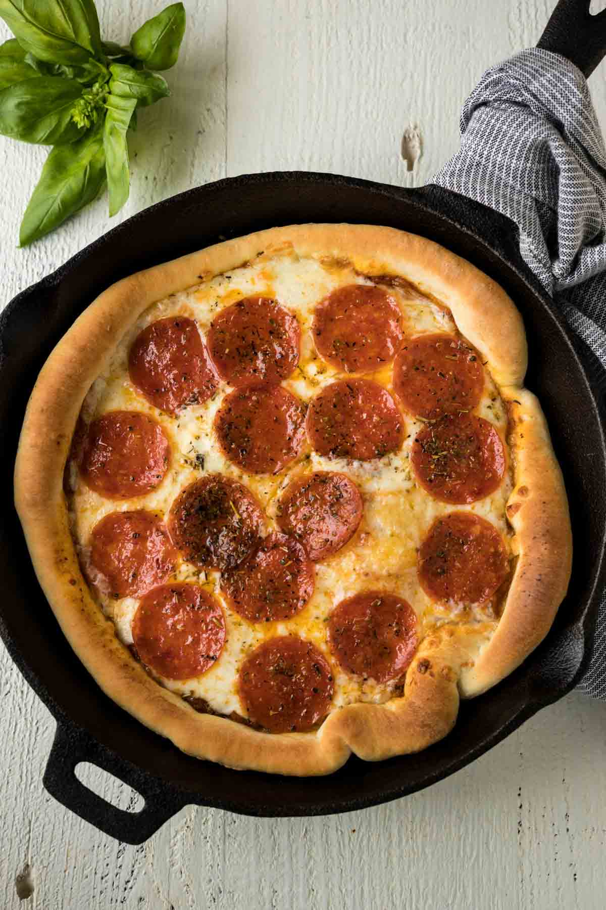 Cast iron skillet pizza with pepperoni and cheese.