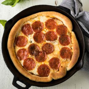 A pepperoni pizza in a cast iron skillet.