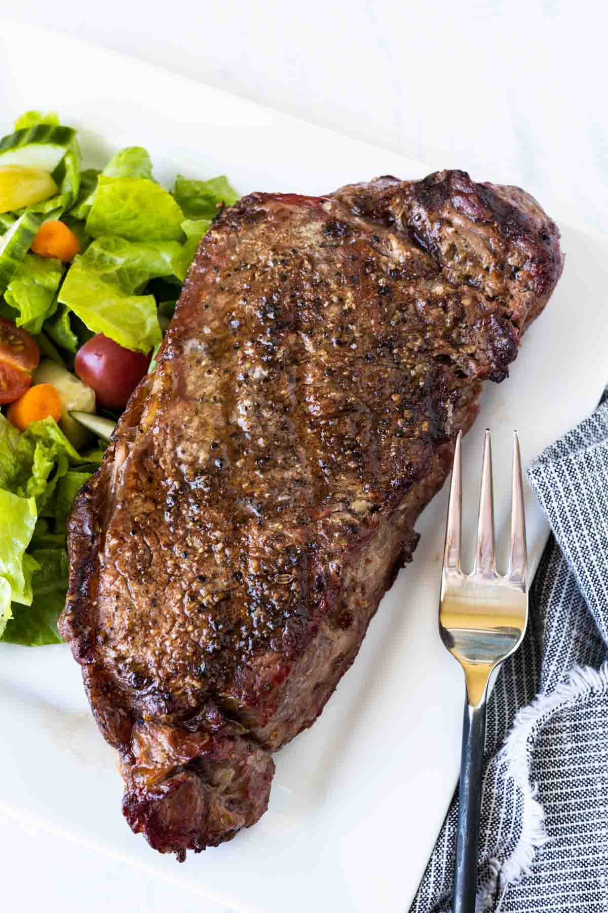 Grilled strip steak with a green salad.