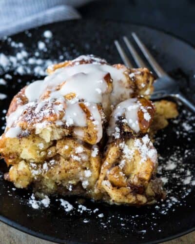 Cinnamon roll egg bake drizzled with icing and dusted with powdered sugar.