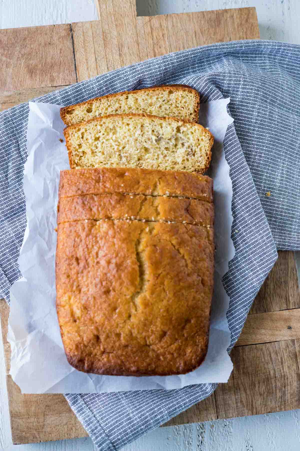 A loaf of sliced banana bread on a wooden cutting board.