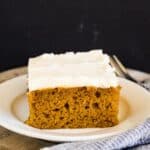 A slice of homemade pumpkin cake with cream cheese icing.