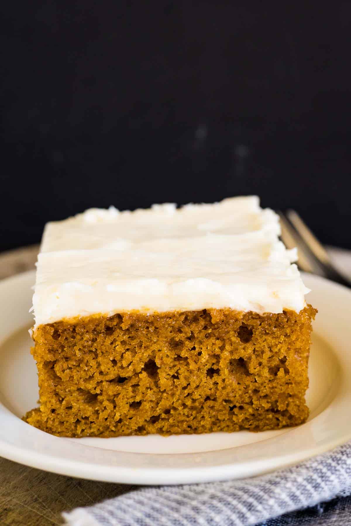 A piece of pumpkin sheet cake with cream cheese icing.