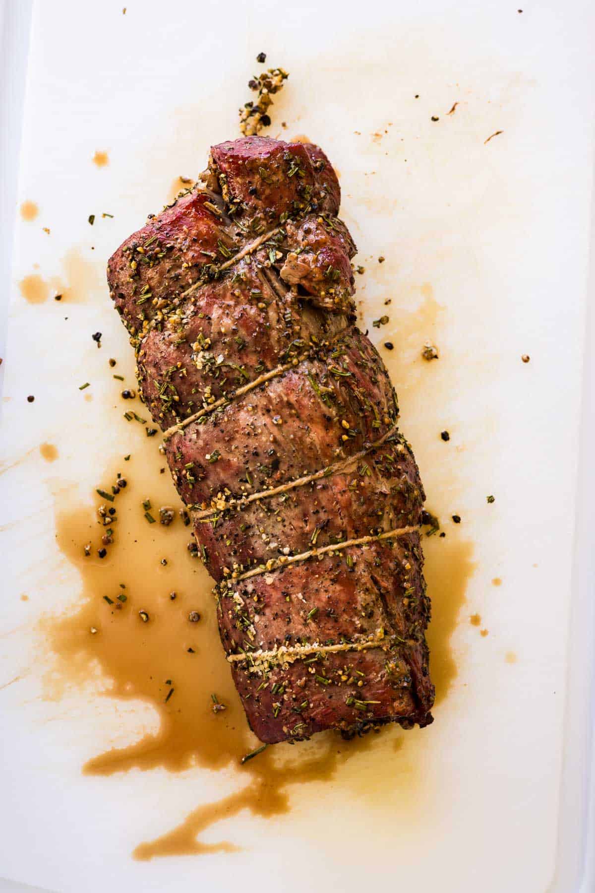 Smoked center cut beef tenderloin roast on a cutting board.