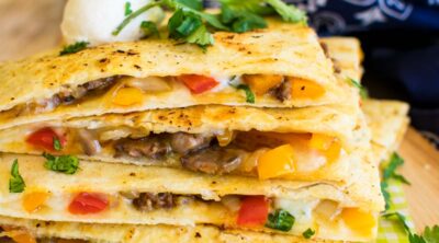 A steal quesadilla filled with bell peppers and sauteed onions and lots of cheese.