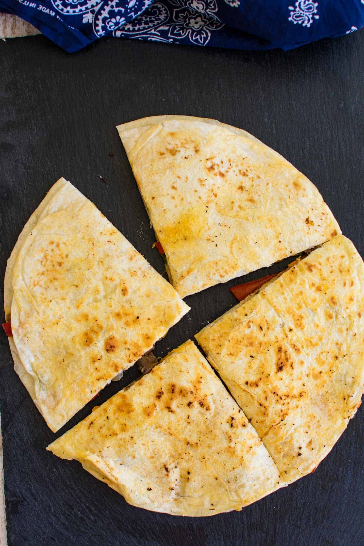 A golden brown fried cheese quesadilla cut into wedges.