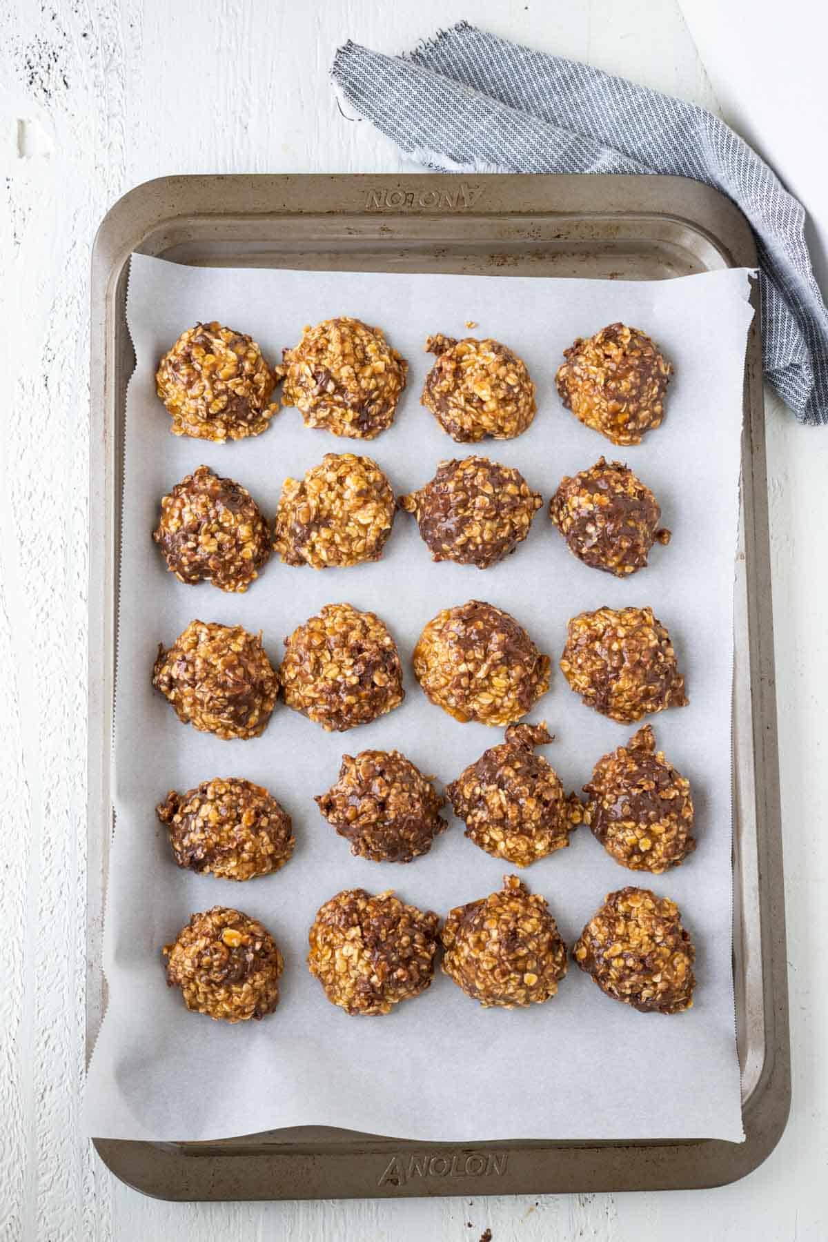 No bake caramel and oatmeal cookies scooped and dropped on a parchment lined cookie sheet.