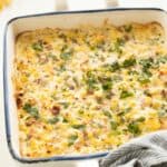 A baking dish with baked corn dip sprinkled with fresh cilantro.