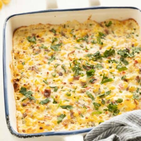 A baking dish with baked corn dip sprinkled with fresh cilantro.