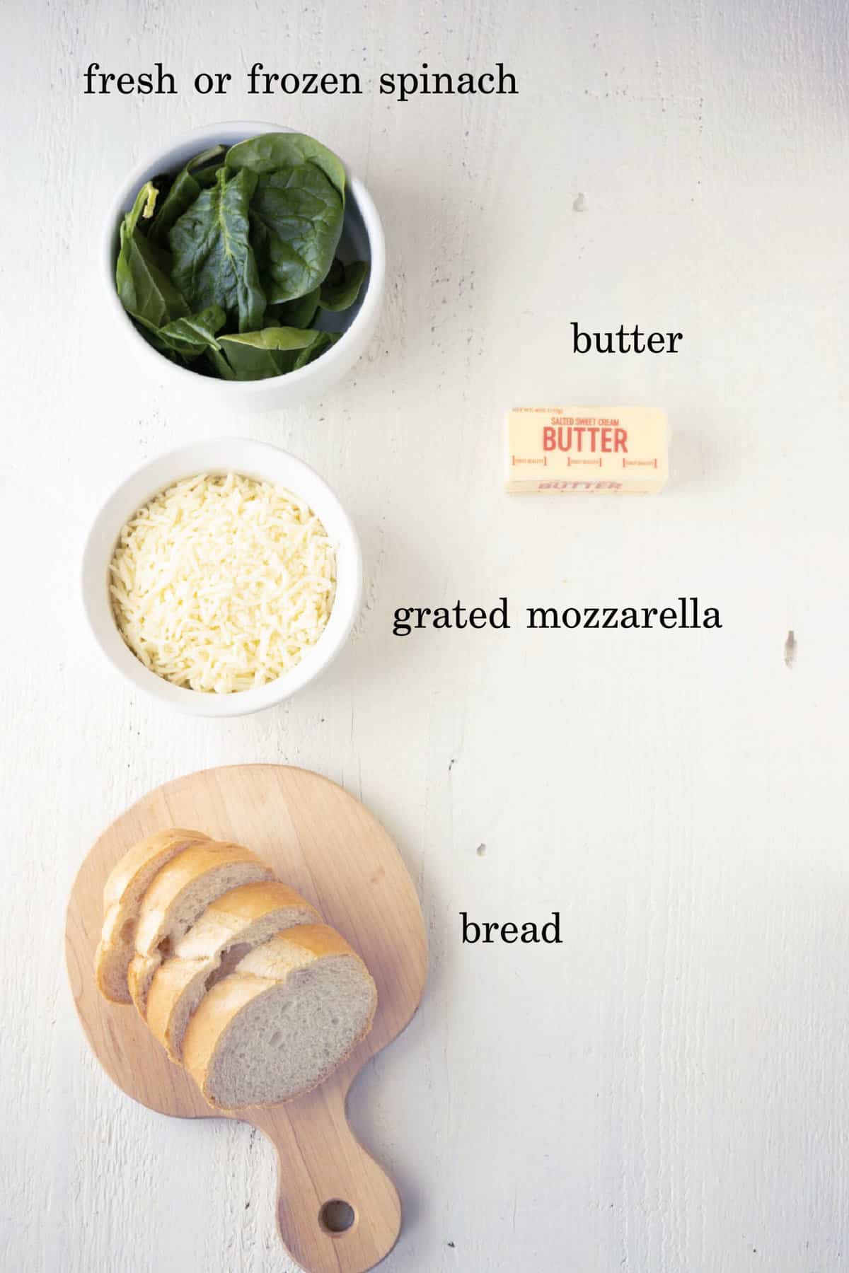 Spinach, grated mozzarella cheese, butter, and bread to make grilled cheese sandwich.