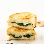 A grilled cheese sandwich with mozzarella cheese and fresh spinach.
