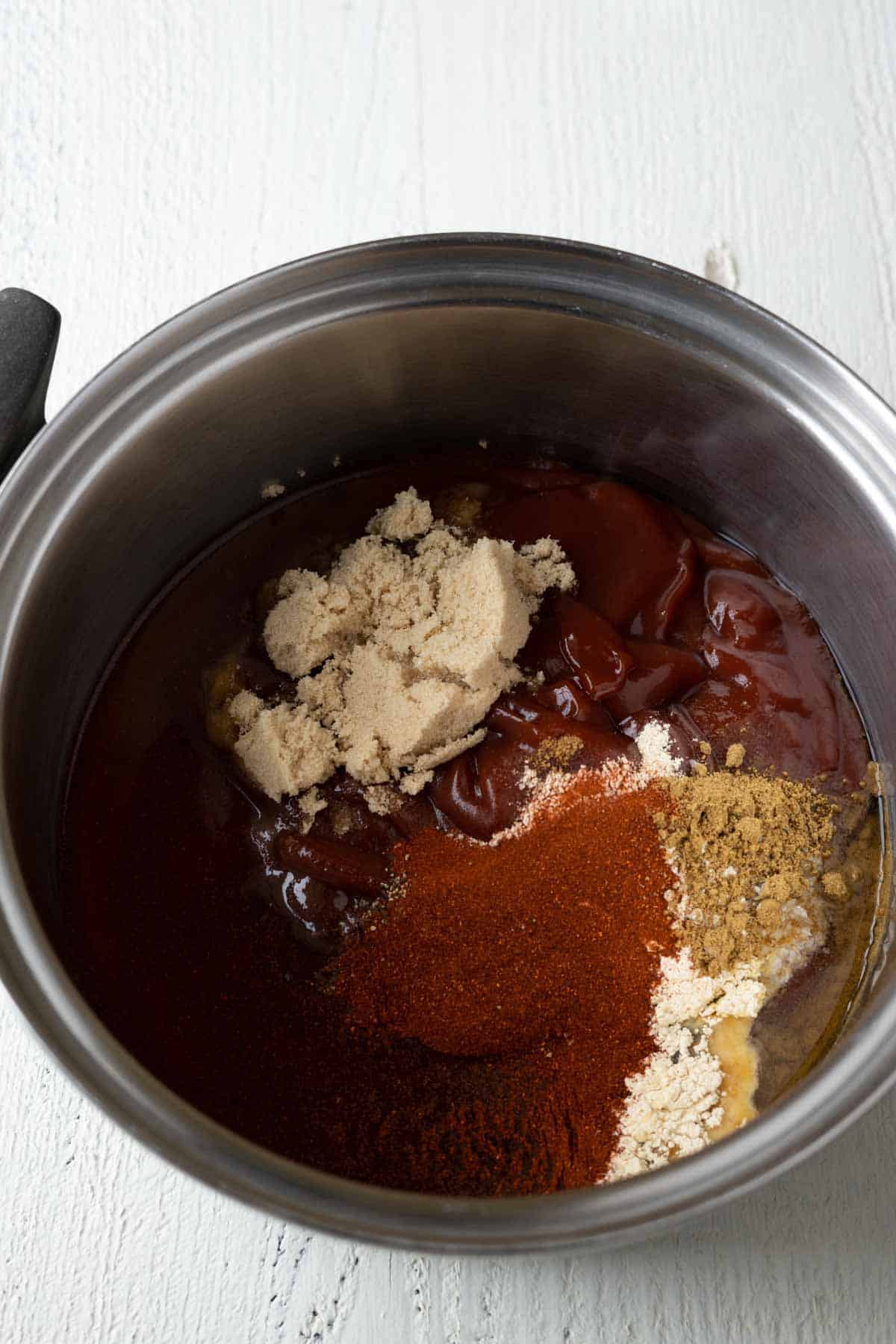 Ketchup, brown sugar, seasonings, honey, apple cider vinegar, and seasonings in a saucepan to make homemade bbq sauce.