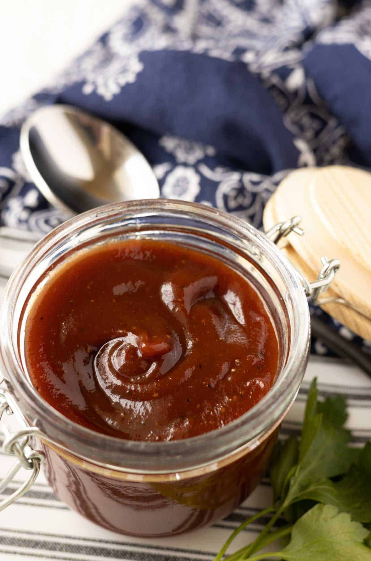 Sweet and tangy bbq sauce that's dark red and thick in a glass jar.