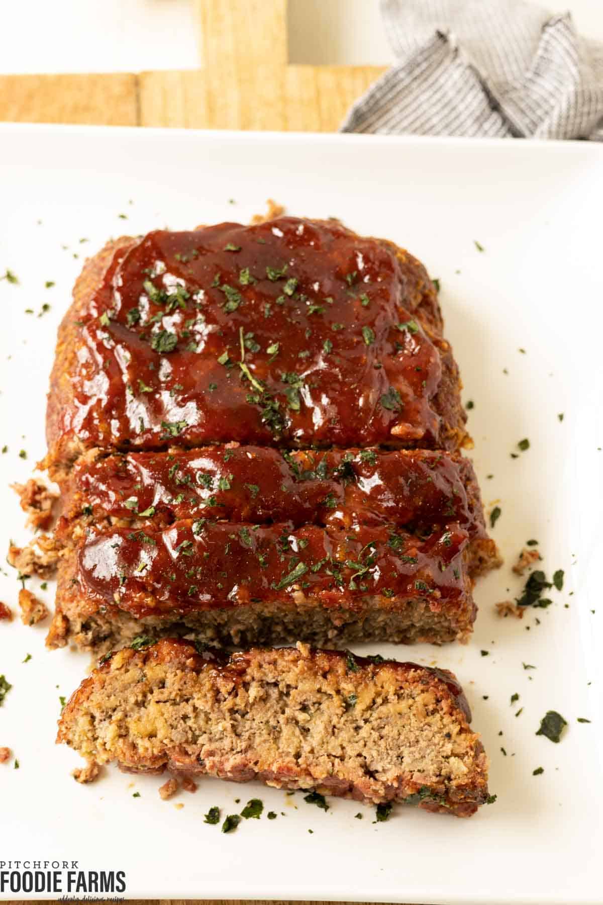 Smoked meatloaf with a barbecue glaze on a white plate.
