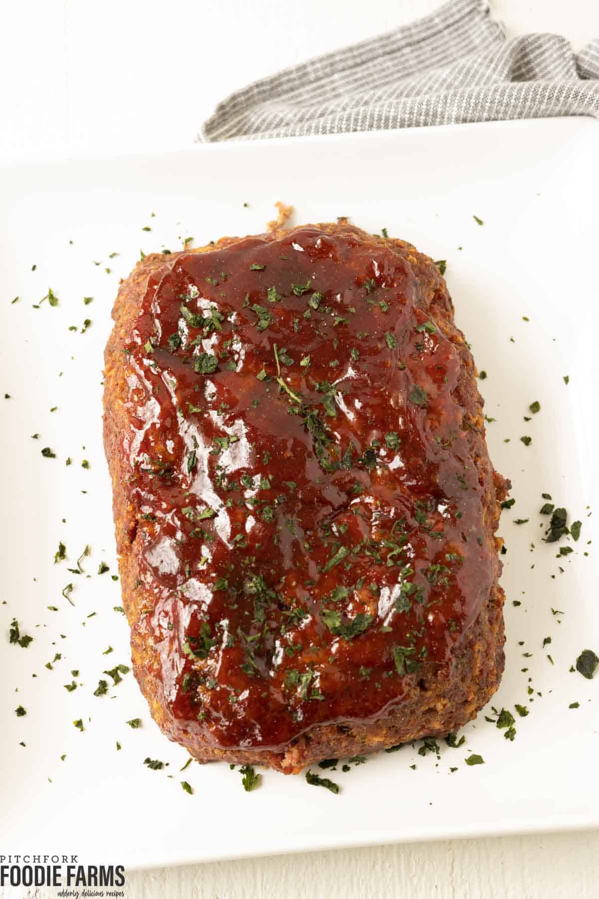 BBQ glazed meatloaf with fresh parsley sprinkled on top.