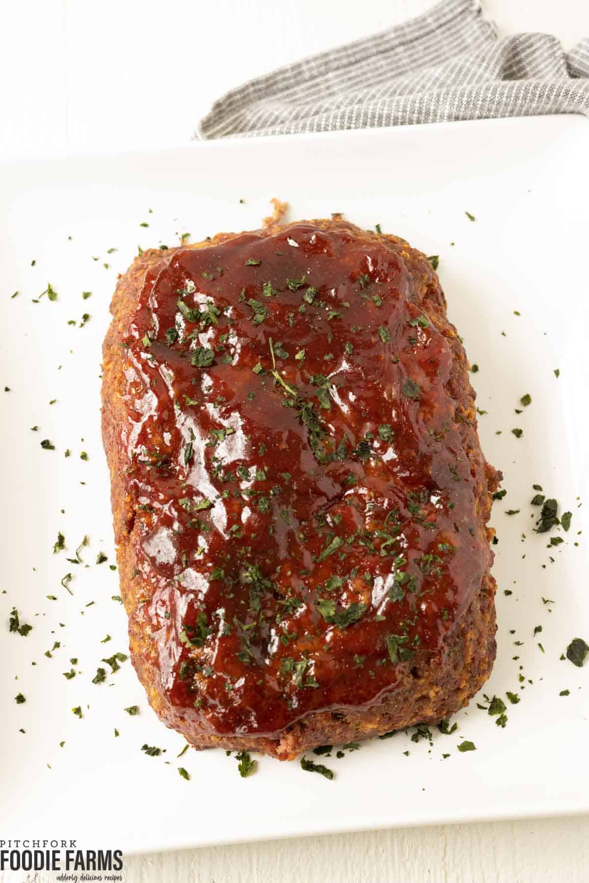 BBQ glazed meatloaf with fresh parsley sprinkled on top. 