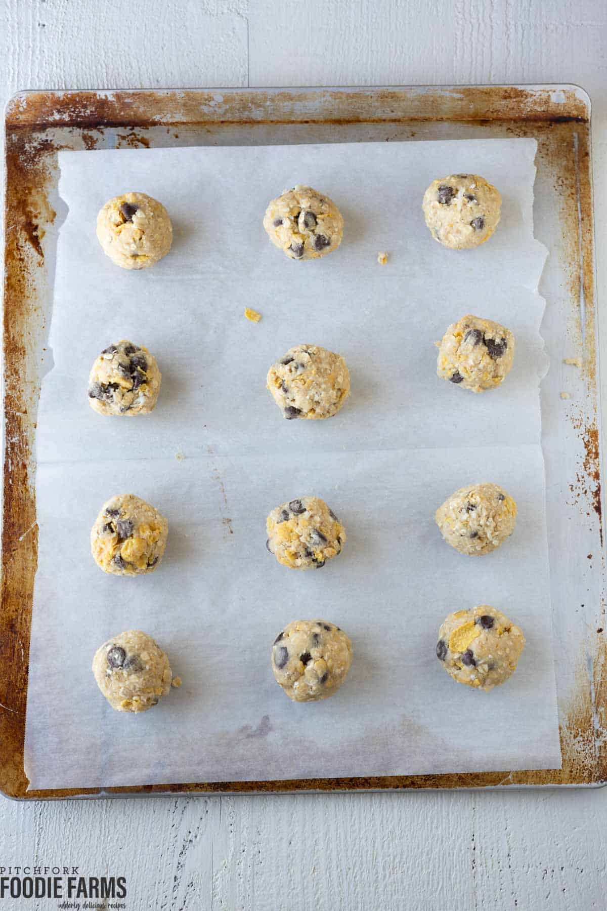 Ranger cookie dough on a parchment paper lined baking sheet.