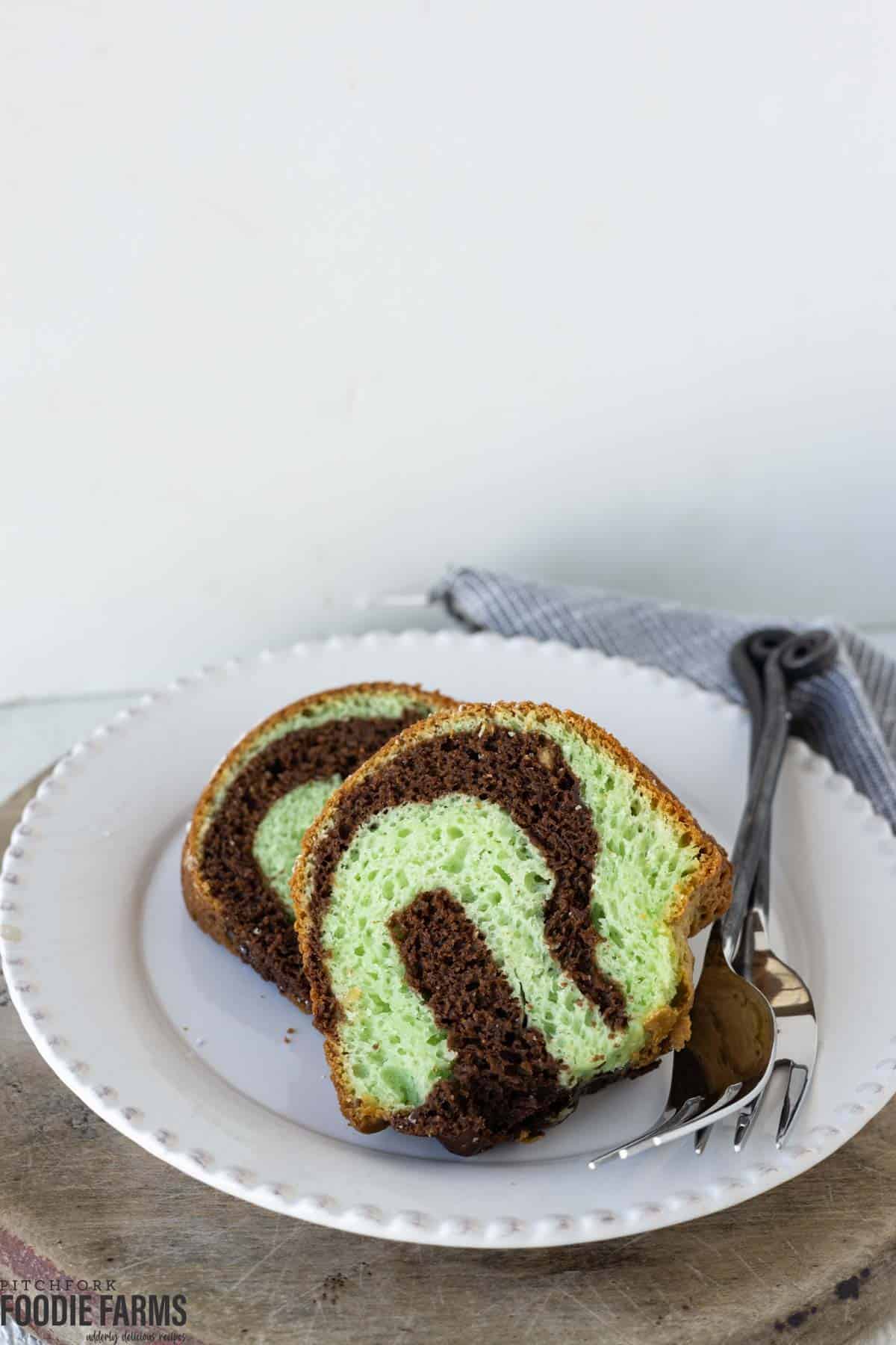 Slices of swirled chocolate and pistachio cake on a plate.