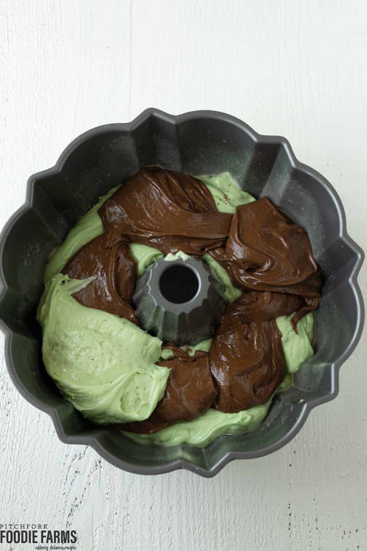 A bundt pan with layers of pistachio and chocolate cake.