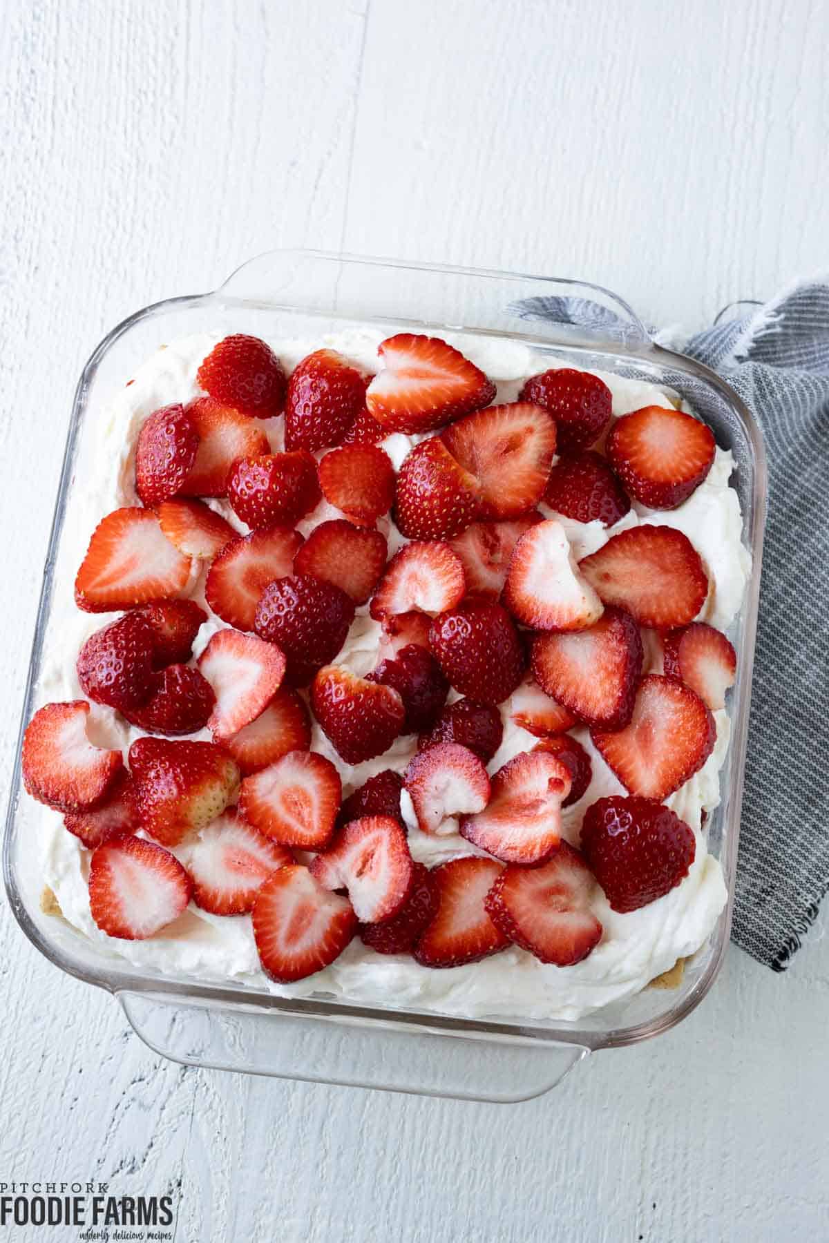 A cream cheese icebox cake with sliced fresh strawberries on top