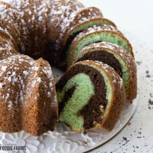 Chocolate pistachio bundt cake with swirls topped with powder sugar.