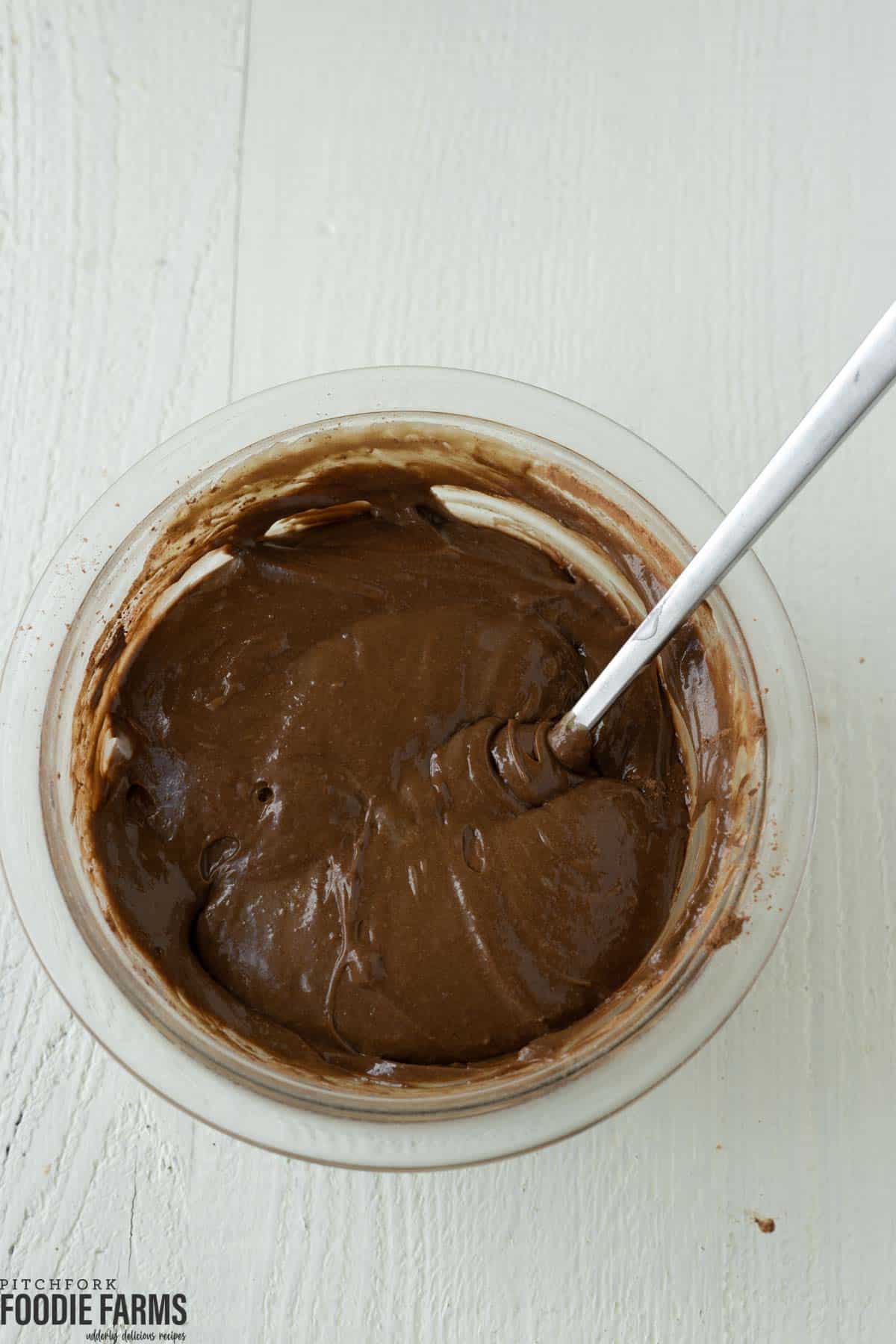 Chocolate and pistachio cake batter in a mixing bowl.