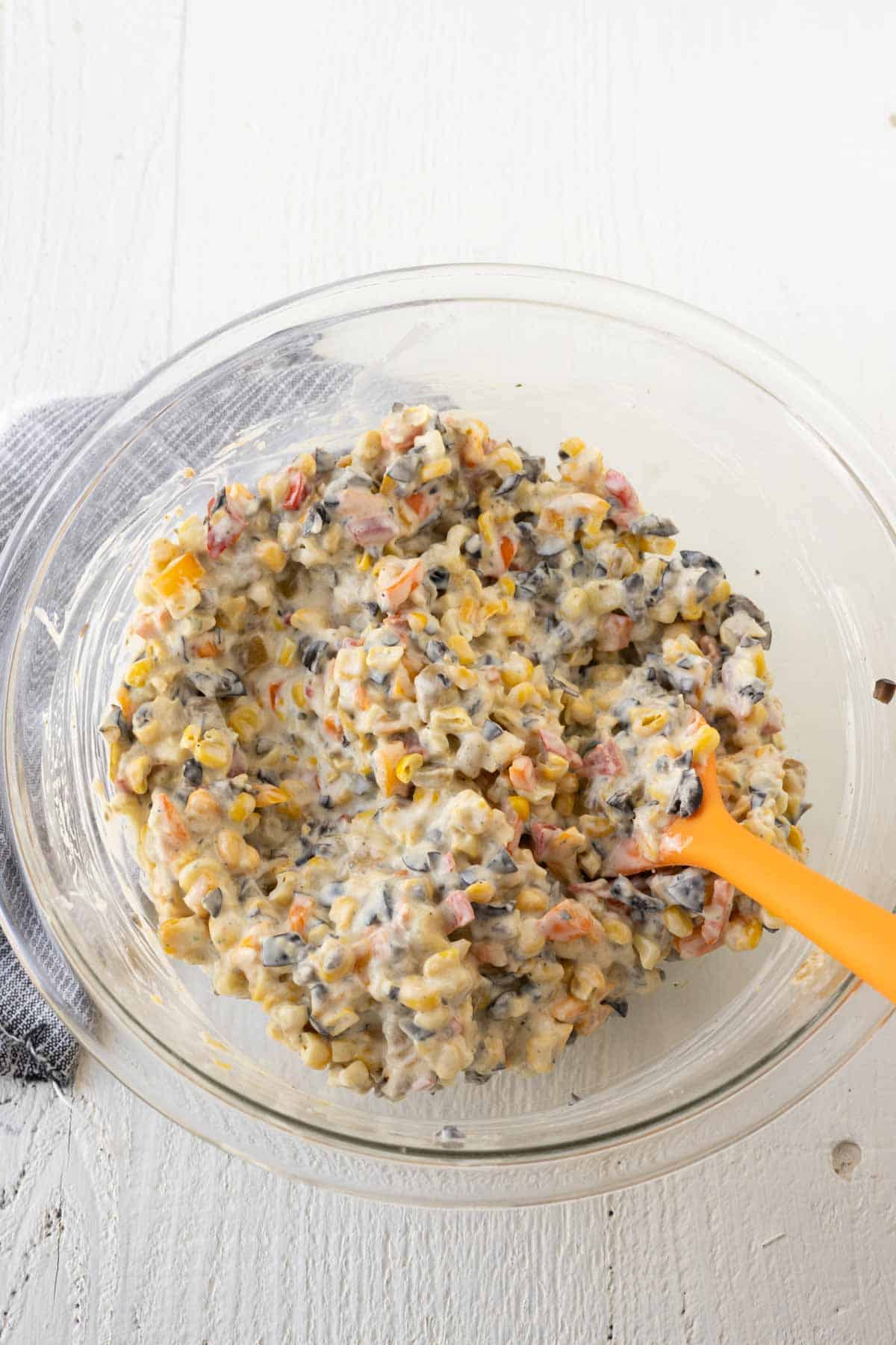 A mixing bowl with poolside dip and a spatula.