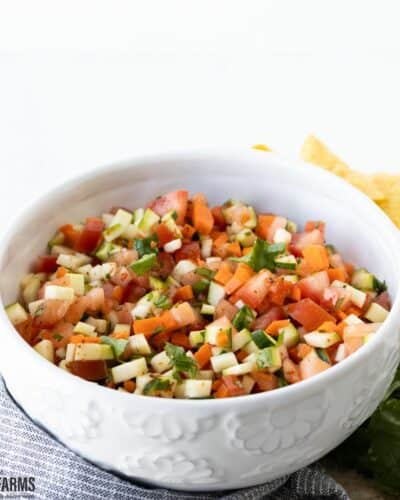 A white bowl with zucchini squash salsa and chips.