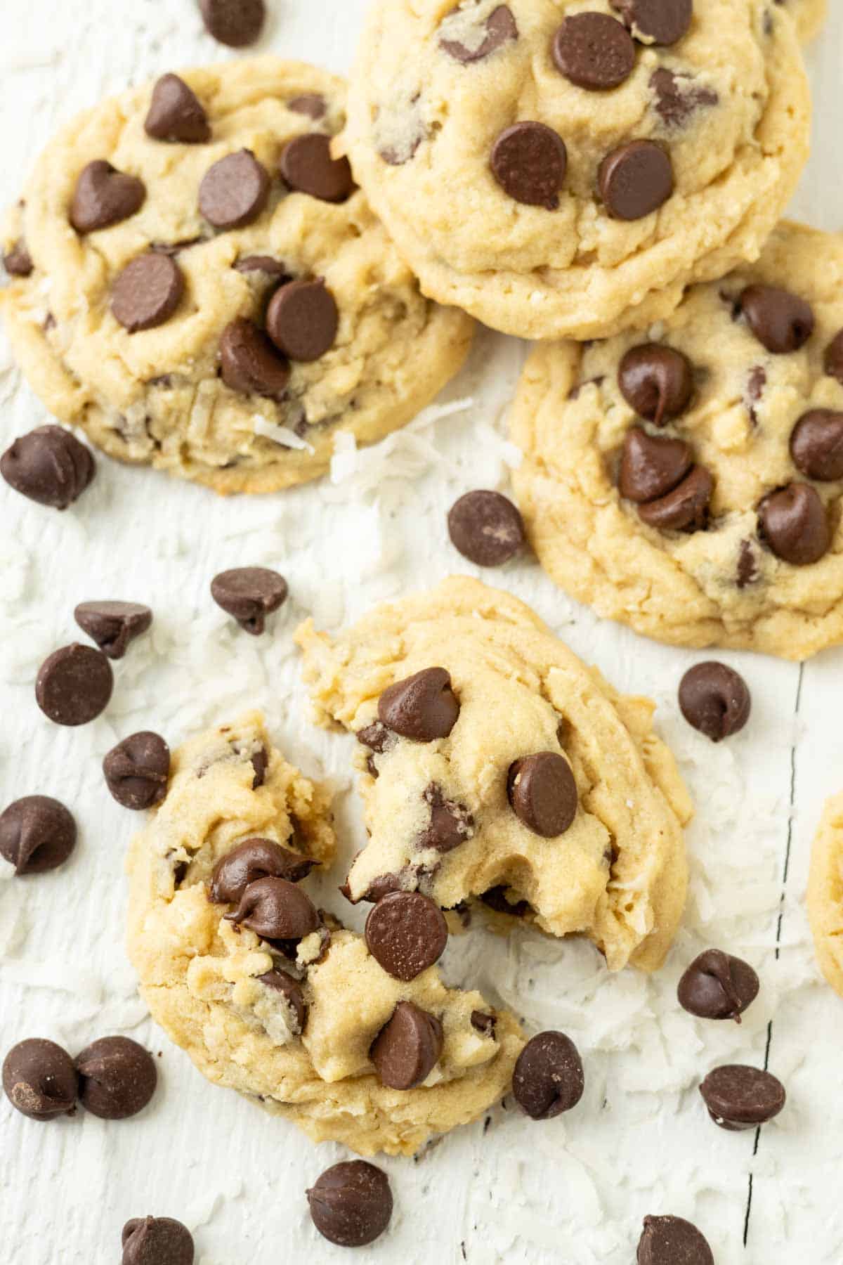 A coconut cookie with chocolate chips and coconut sprinkled around it.