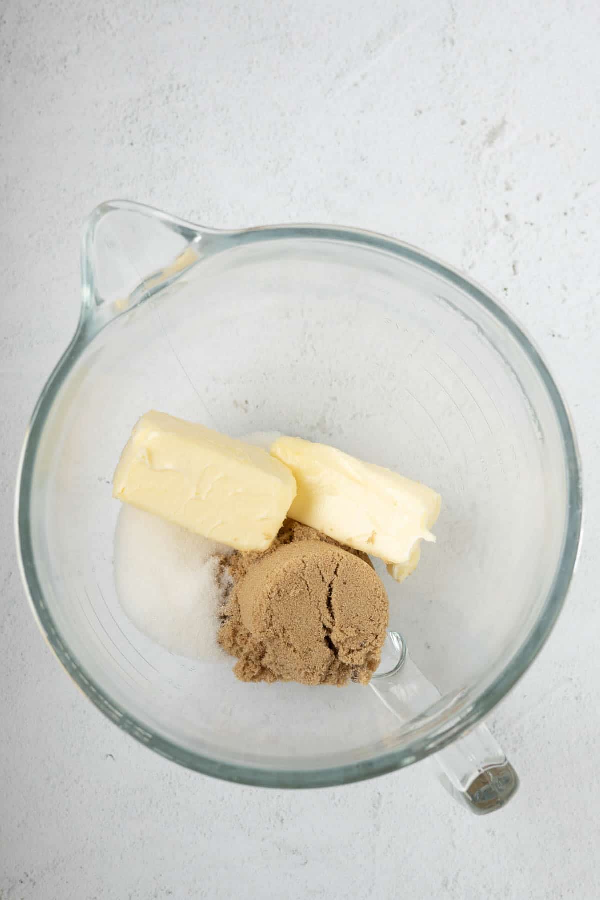 Butter, brown sugar, and white sugar in a mixing bowl.